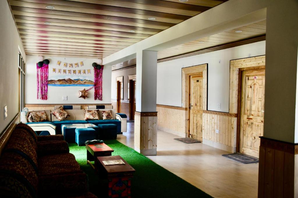 a living room with a couch and a green rug at Grand Himalaya Homestay Pangong by LexStays in Meruk