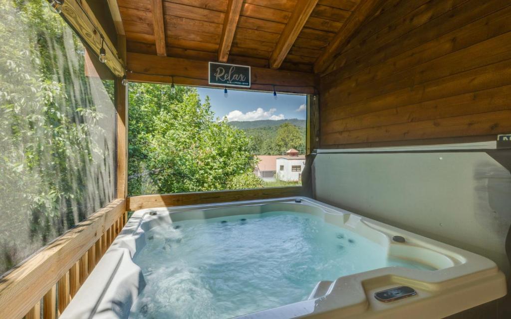 a hot tub in a house with a window at The Foxtail Lodge in Gatlinburg