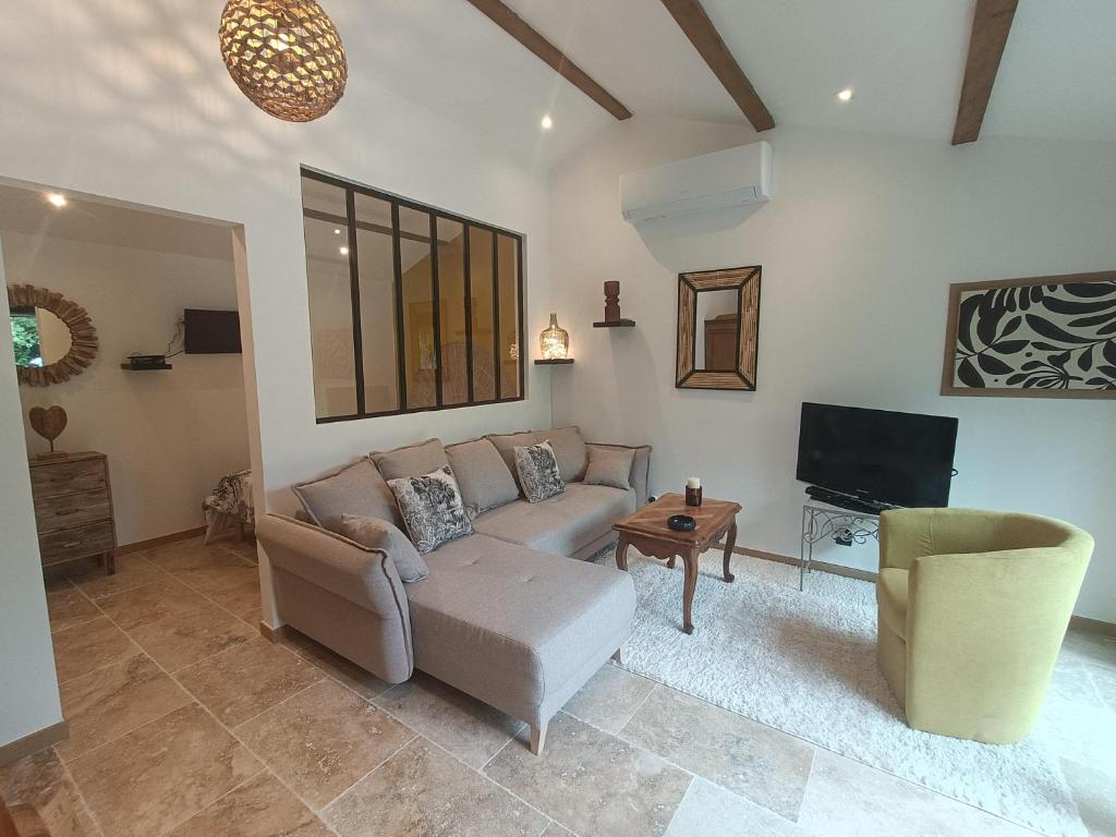 un salon avec un canapé et une télévision dans l'établissement Gîte T2 au mas Aguilhon, à Saint-Marcel-dʼArdèche