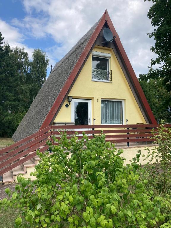a thatch roofed house with a window at Finnhütte 7 Mönchgut in Lobbe