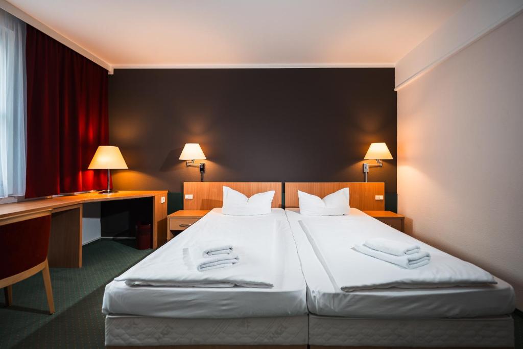Postel nebo postele na pokoji v ubytování martas Hotel Lutherstadt Wittenberg