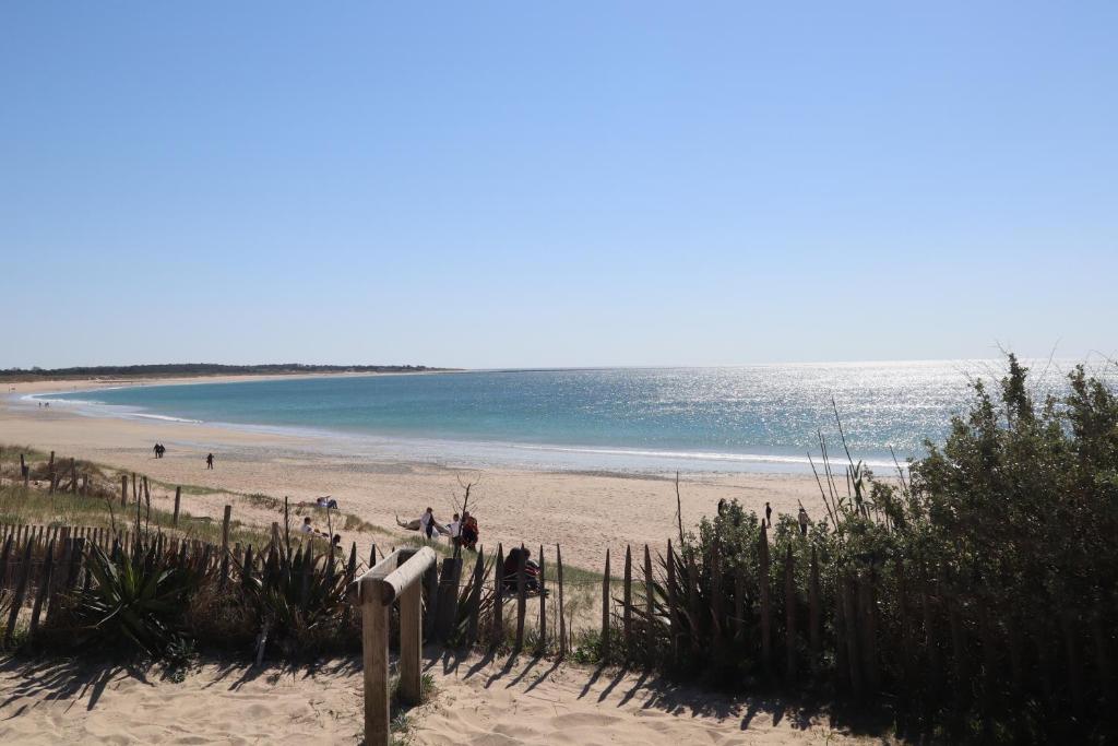- une plage avec des gens sur le sable et l'océan dans l'établissement Villa Margot, à Saint-Pierre-dʼOléron