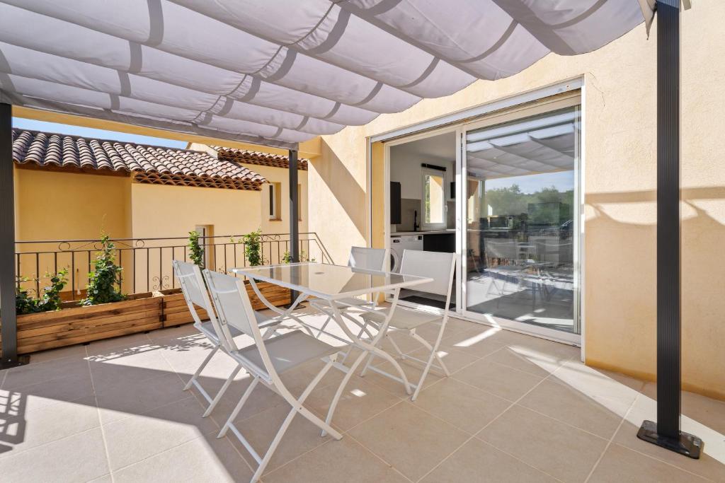 un patio avec une table et des chaises sur un balcon dans l'établissement L'Oliveraie, à Solliès-Ville