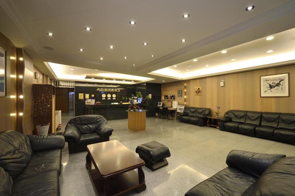 a waiting room with leather couches and a bar at Jiuning Business Hotel in Tainan