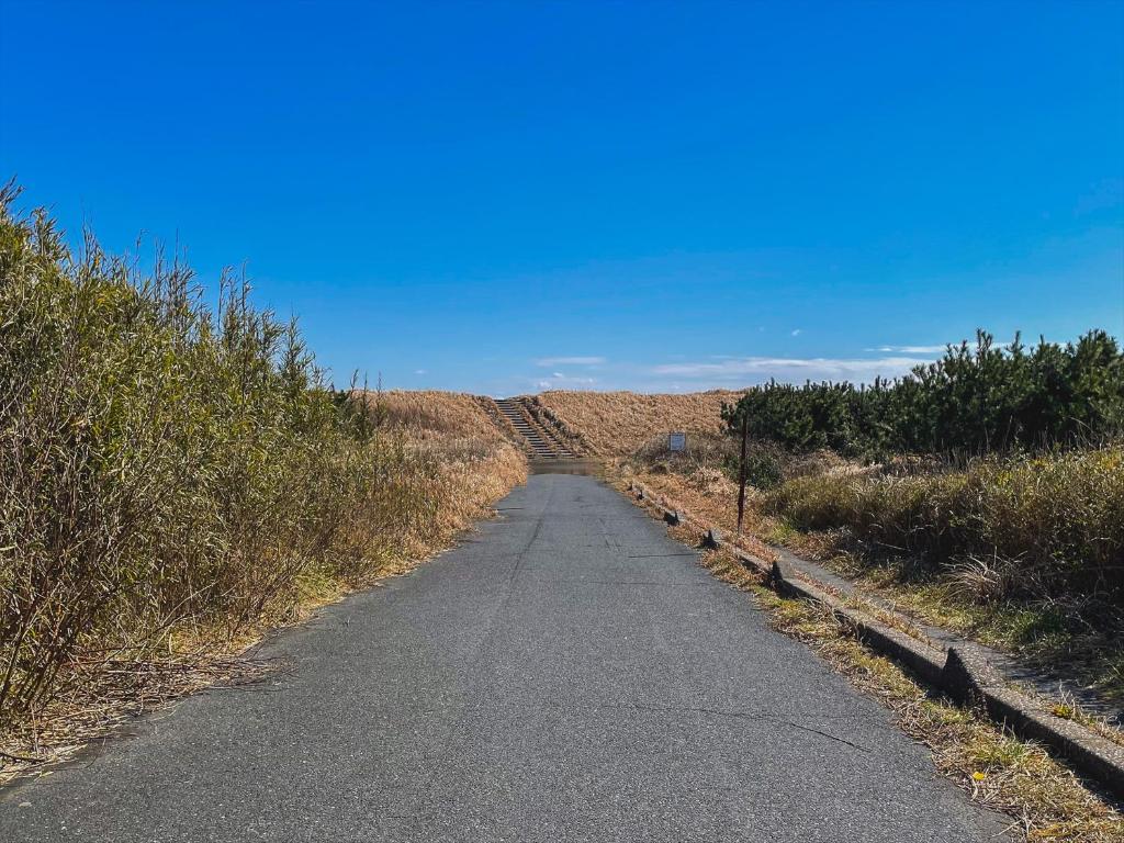 an empty road in the middle of a field at Seage Torami Coastside in Ichinomiya