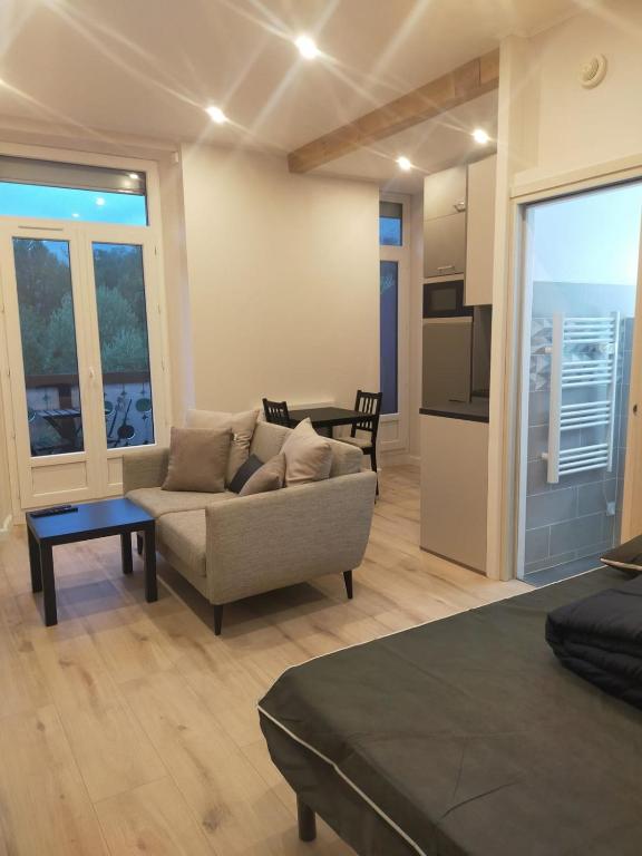 un salon avec un canapé et une table dans l'établissement #FP The Golfer's Nest - Studio - Uriage, à Vaulnaveys-le-Haut