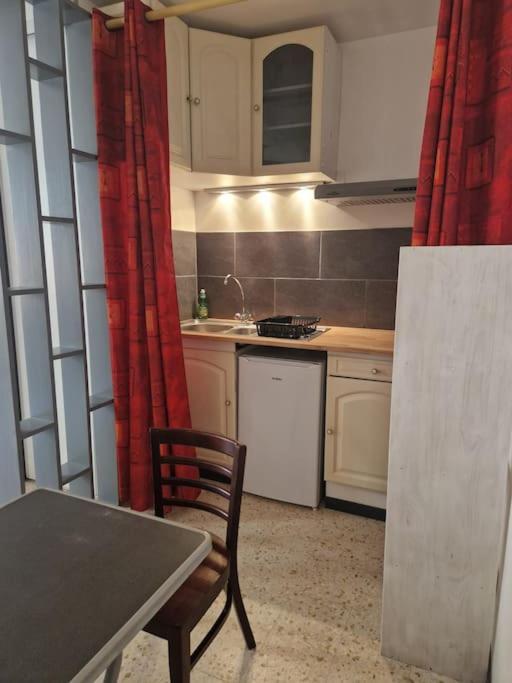 une cuisine avec une table, une table et une chaise dans l'établissement Studio meublé, à Lunel