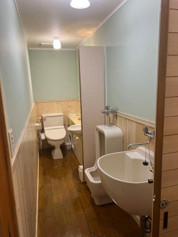 un bagno con 2 servizi igienici, lavandino e servizi igienici. di 天满宿 a Takayama