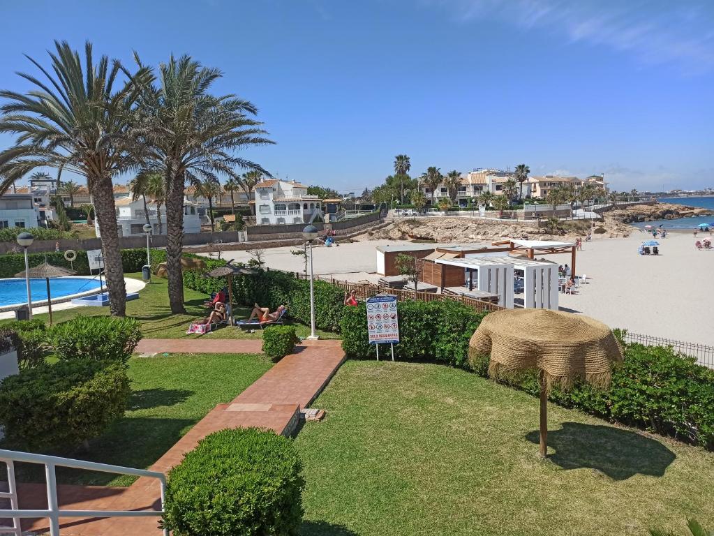 - Vistas a un complejo con playa y piscina en Apartamento en la playa de Cala Capitán -Cabo Roig- Orihuela Costa, en Orihuela