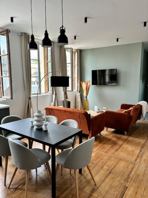 un salon avec une table, des chaises et un canapé dans l'établissement Le Matisse - City center near train station, à Vernon