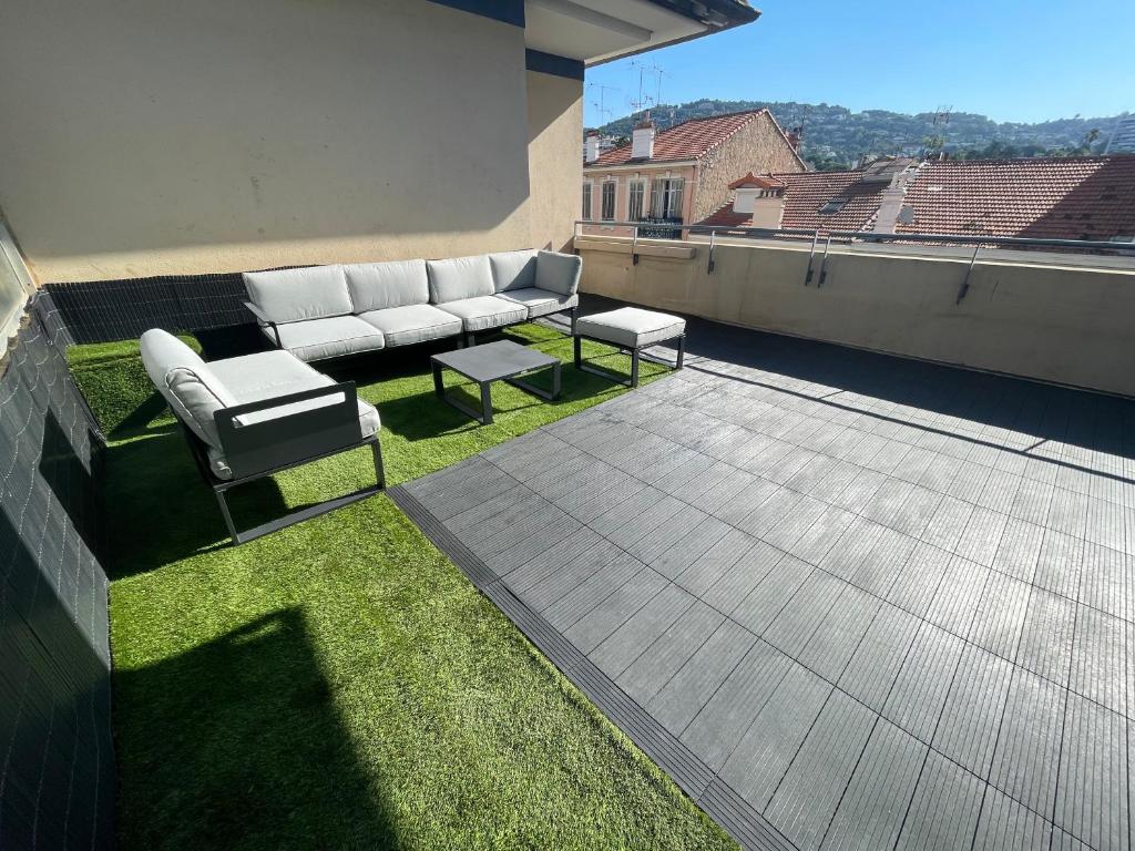 un canapé et deux tables sur le toit dans l'établissement Cannes Appartement Terrasse Parking privé, à Cannes