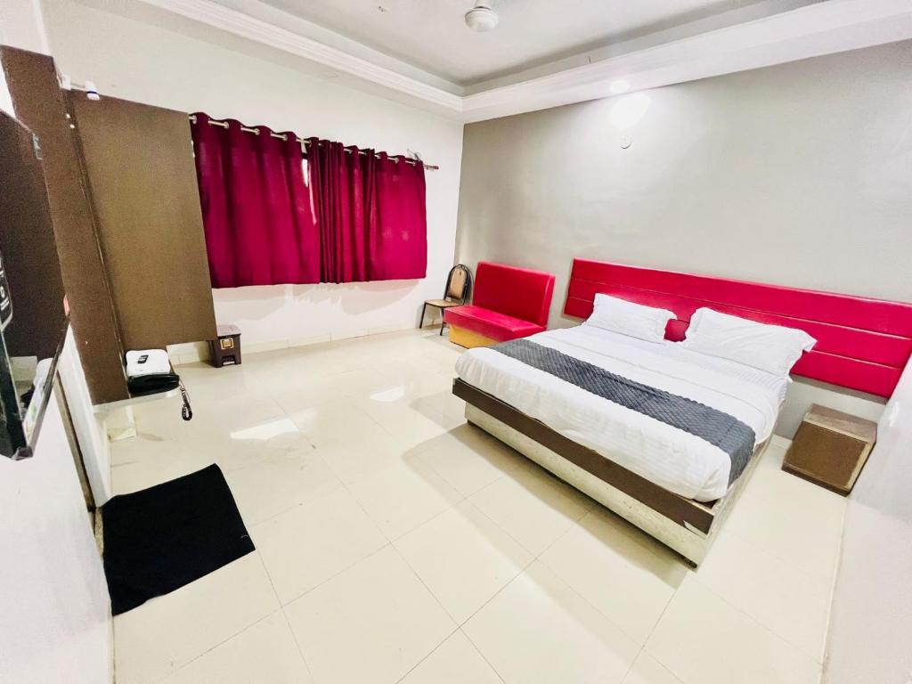 une chambre avec un grand lit avec une tête de lit rouge dans l'établissement Hotel rajlaxmi executive, à Aurangabad