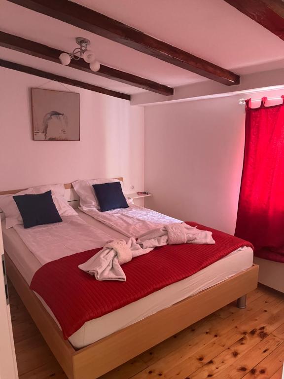 een slaapkamer met een groot bed en een rood gordijn bij Le Liv On in Rijeka
