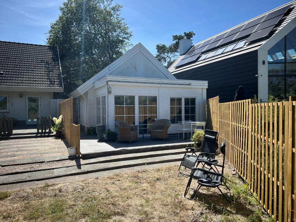 a patio with two chairs and a house at Anda in Zandvoort