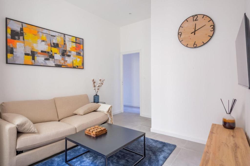 un salon avec un canapé et une horloge au mur dans l'établissement Minimalistic apartment near Vieux-Port by Weekome, à Marseille