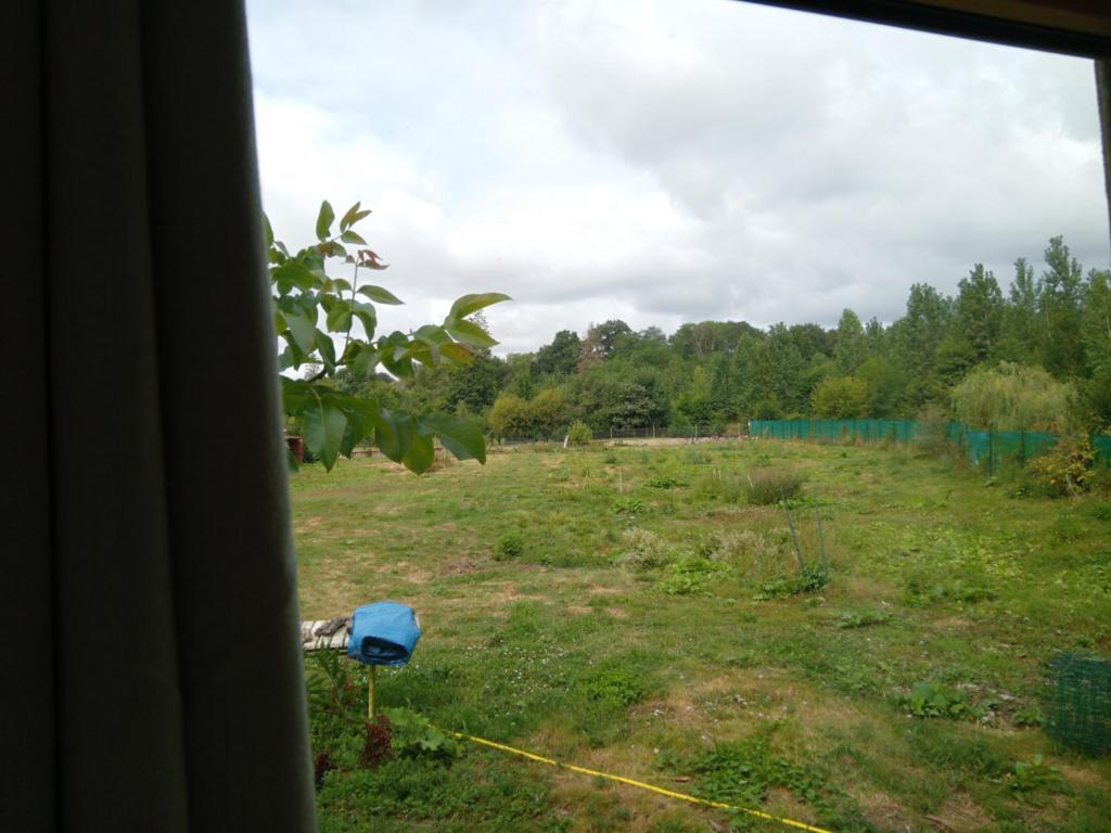 ein Blick auf ein Feld aus einem Fenster in der Unterkunft LESSENCIEL nature in Parthenay