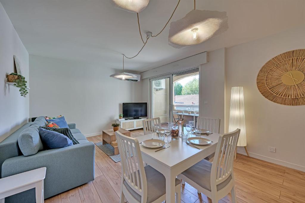 un salon avec une table et un canapé bleu dans l'établissement 333 - Parking - Clim - Terrasse, à Avignon