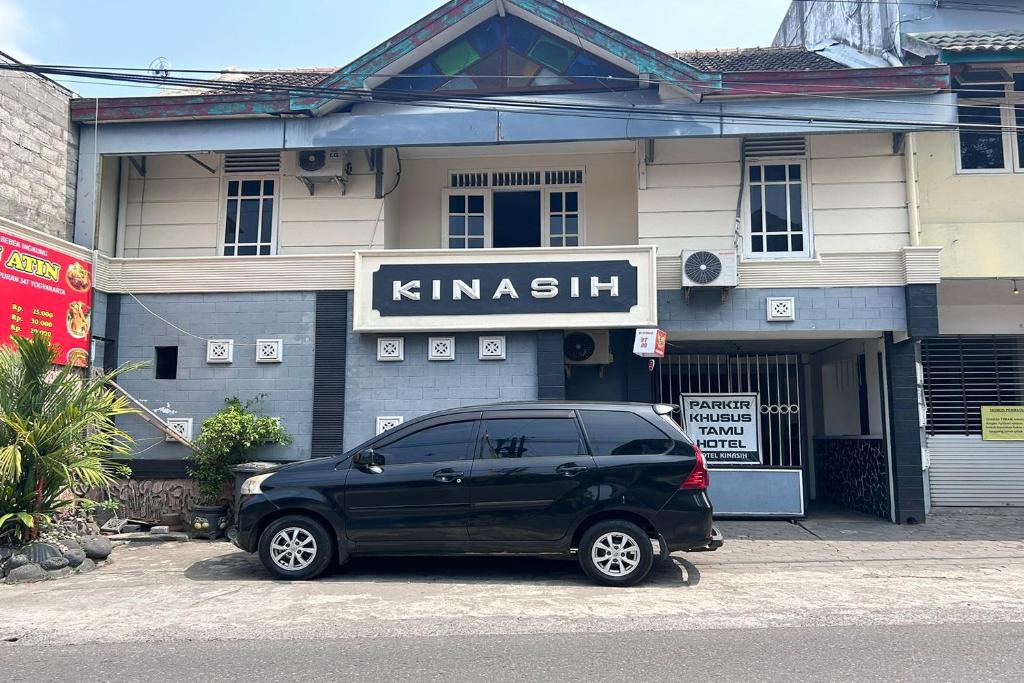 a black minivan parked in front of a building at Hotel Kinasih Yogyakarta in Yogyakarta