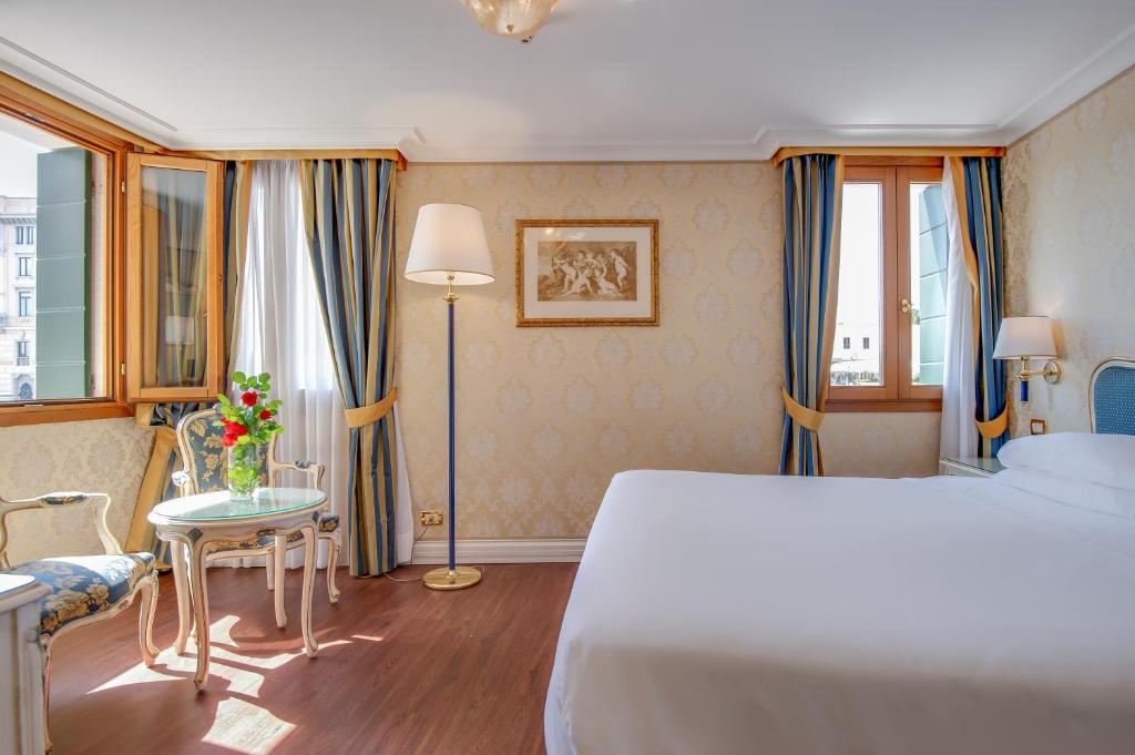 a hotel room with a bed and a table at Hotel Antiche Figure in Venice