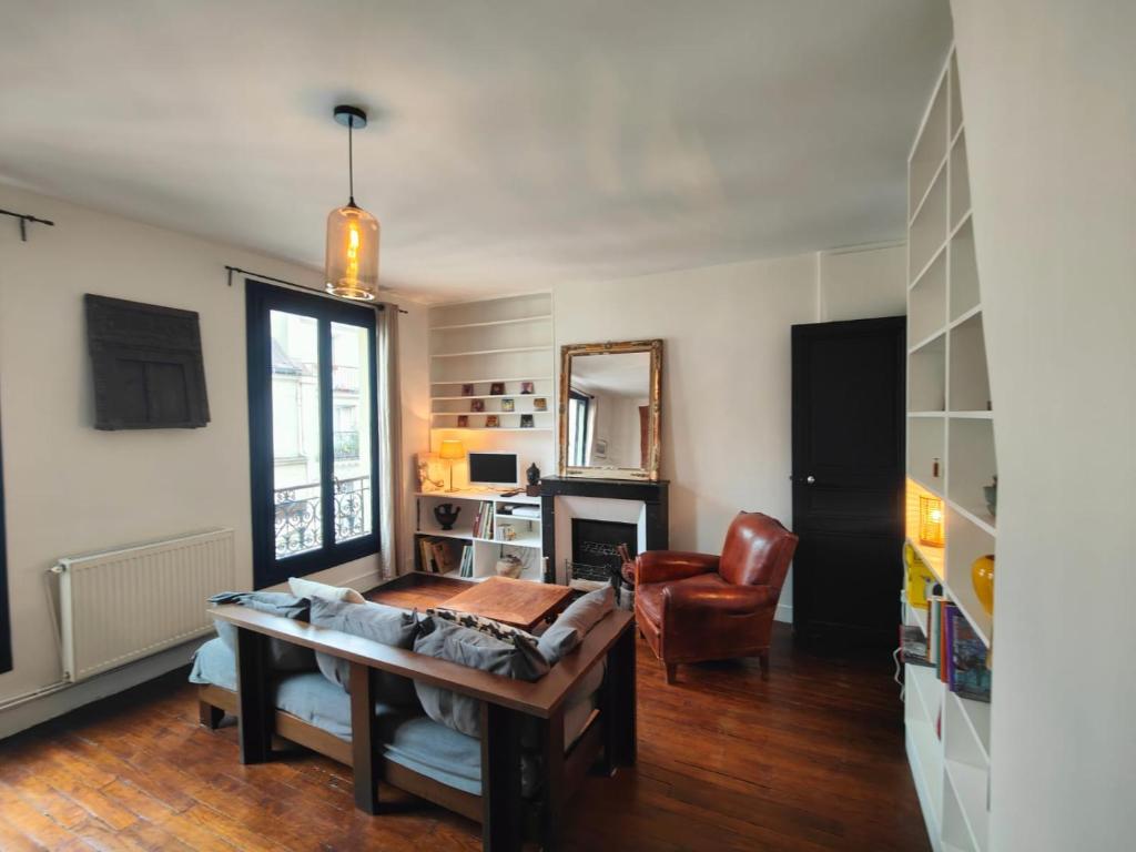 un salon avec une table et une chaise dans l'établissement Summer price Beau 3 pièces près de Montmartre 1, à Paris