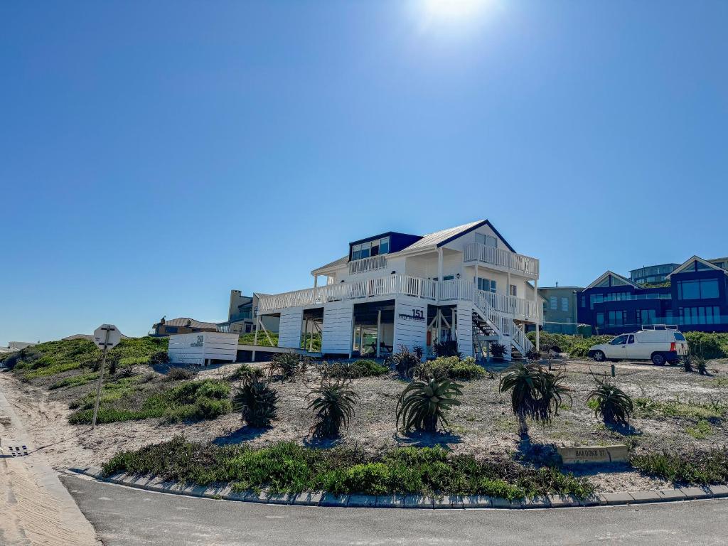 a house on the beach with palm trees in front of it at Villa Bandarra in Yzerfontein