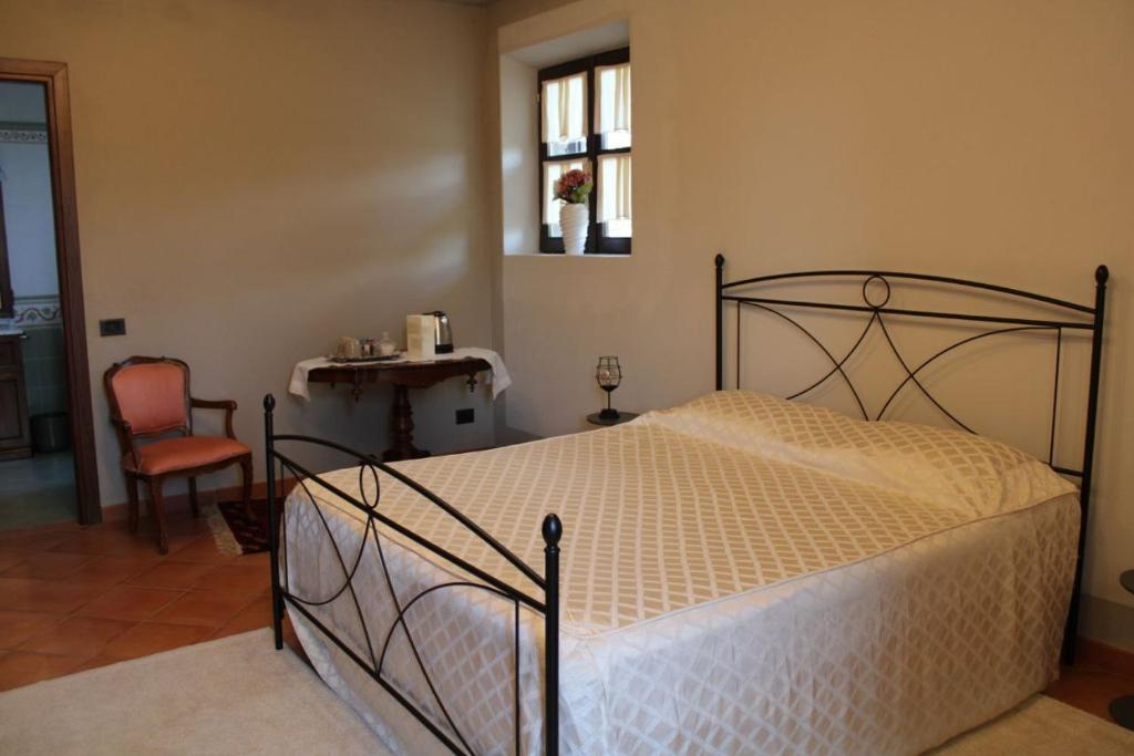 sypialnia z łóżkiem, stołem i krzesłem w obiekcie LA CASA DI TALIN w mieście Serravalle delle Langhe
