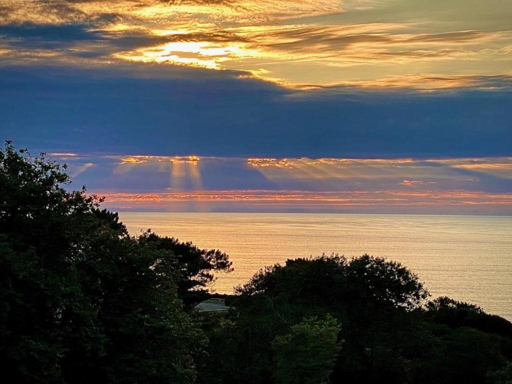 - une vue sur l'océan au coucher du soleil avec une ligne de nuages dans l'établissement Villa Denise, à Bidart