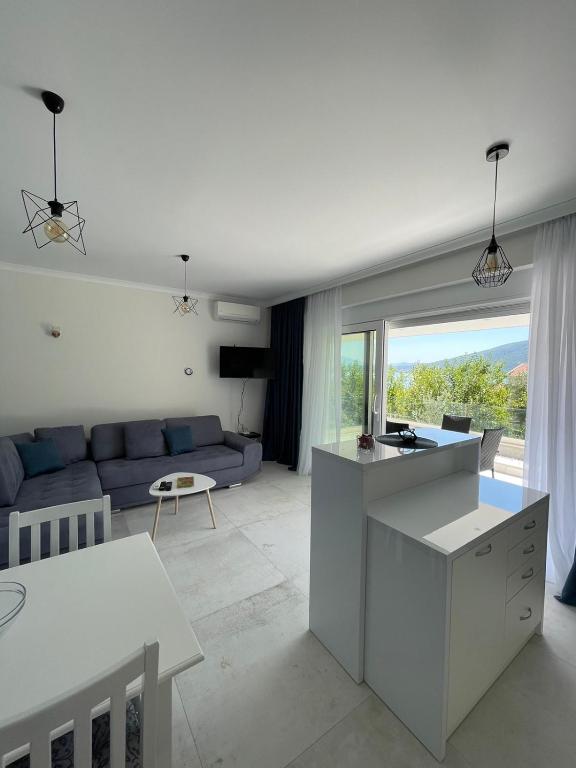 Una cocina y una sala de estar con un sofá azul. en Villa Le Grand Bleu, en Ðenovići
