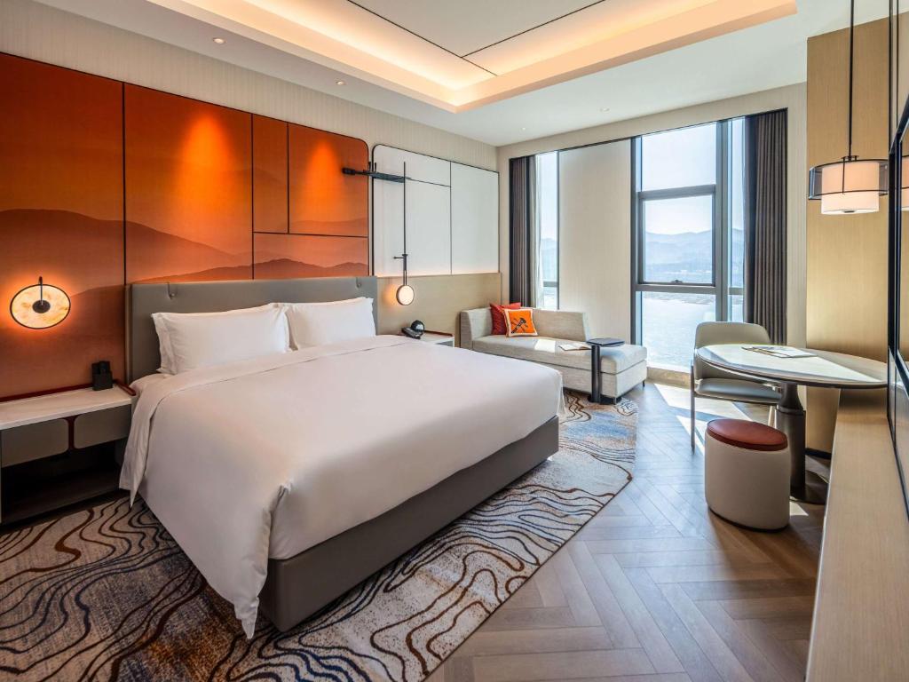 Postel nebo postele na pokoji v ubytování Grand Mercure Yichang Waitan