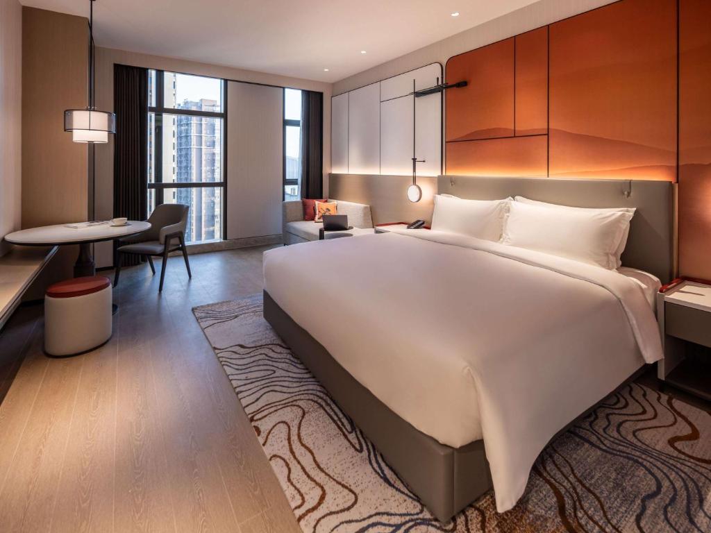Postel nebo postele na pokoji v ubytování Grand Mercure Yichang Waitan