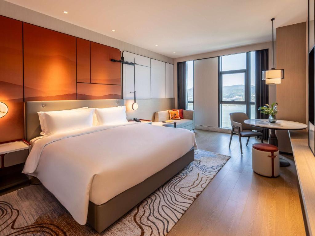 Postel nebo postele na pokoji v ubytování Grand Mercure Yichang Waitan