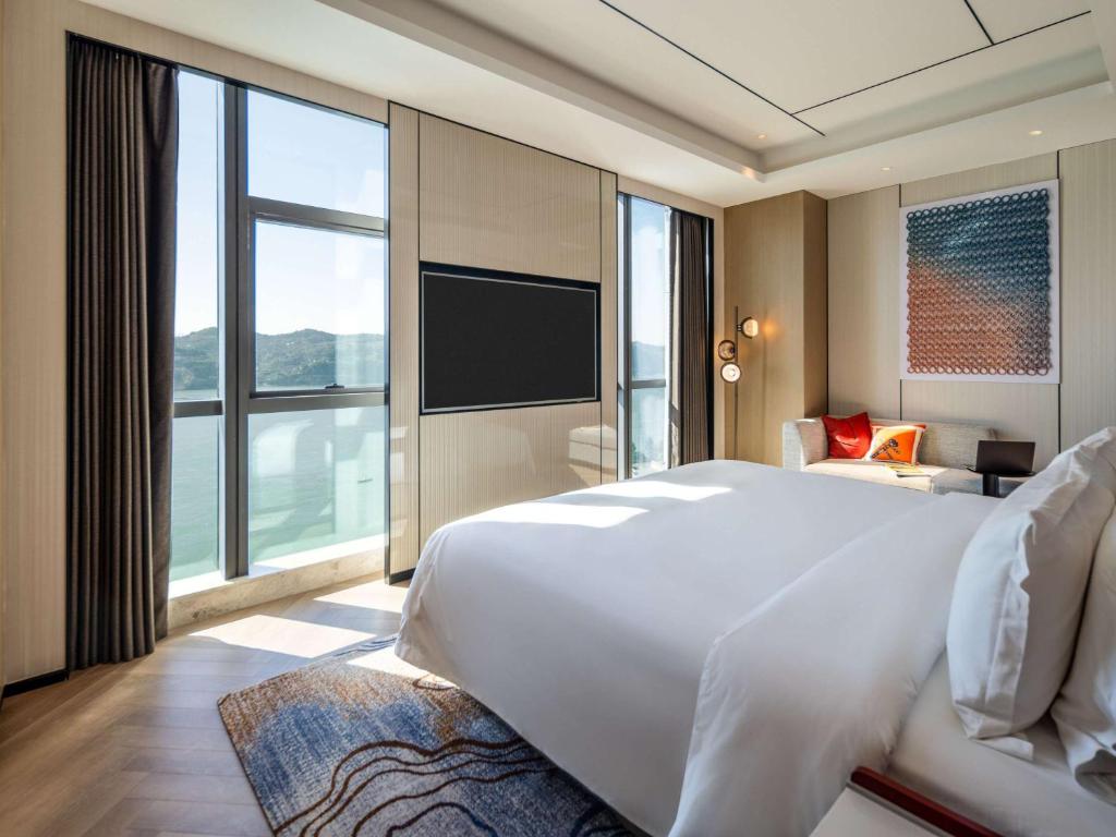 Postel nebo postele na pokoji v ubytování Grand Mercure Yichang Waitan