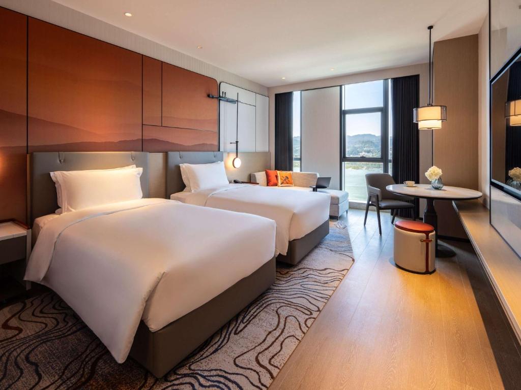 Postel nebo postele na pokoji v ubytování Grand Mercure Yichang Waitan