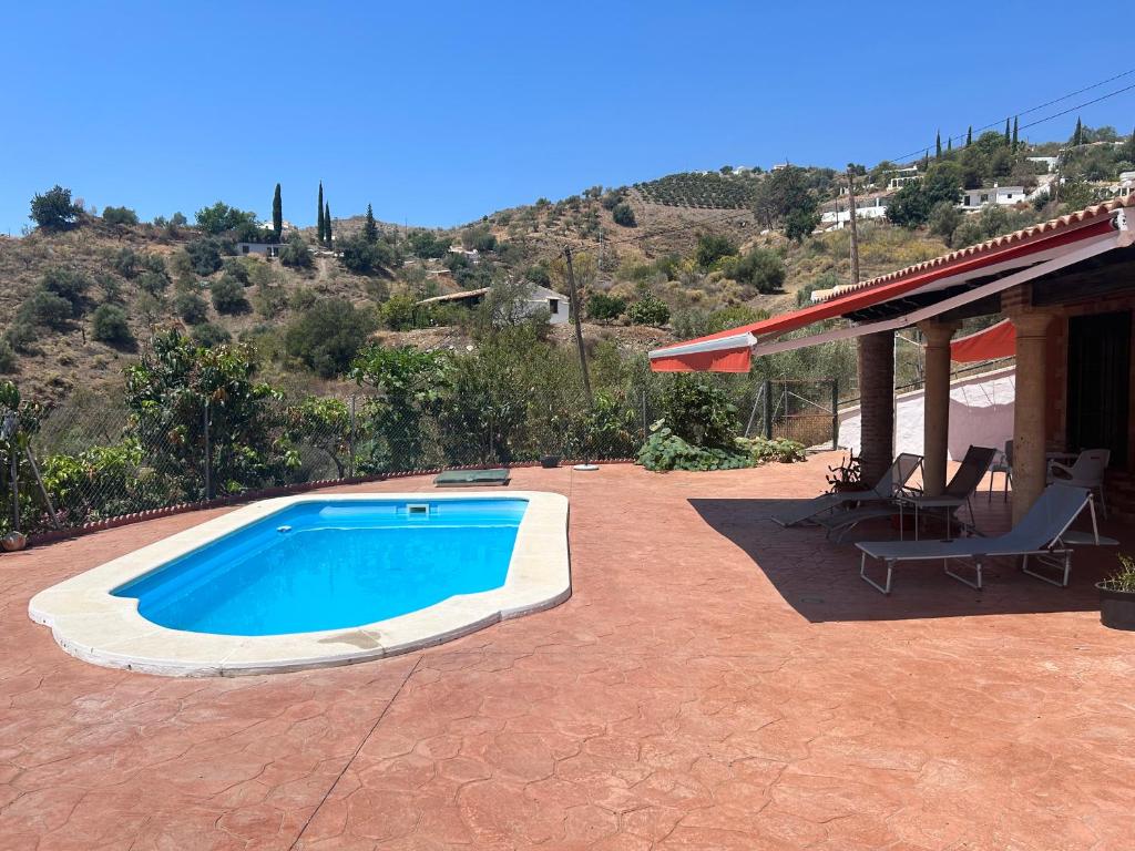 a swimming pool on a patio with a house at TIERRA NUEVA Familiar experience in Torre de Benagalbón