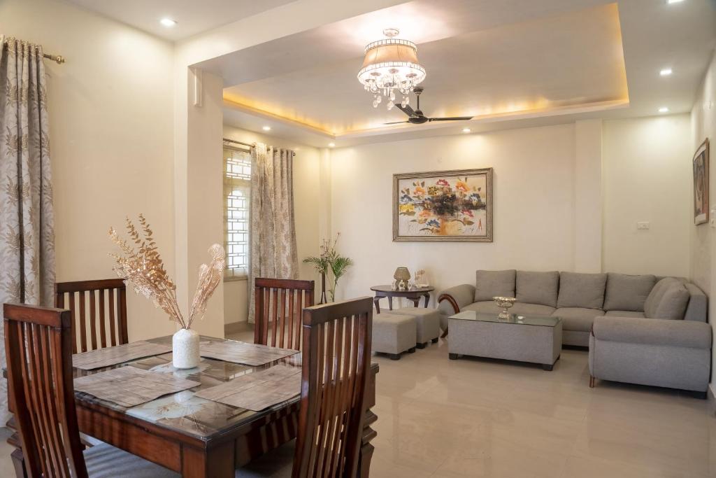 una sala de estar con una mesa y un sofá en The Urban Grandeur 1, en Guwahati