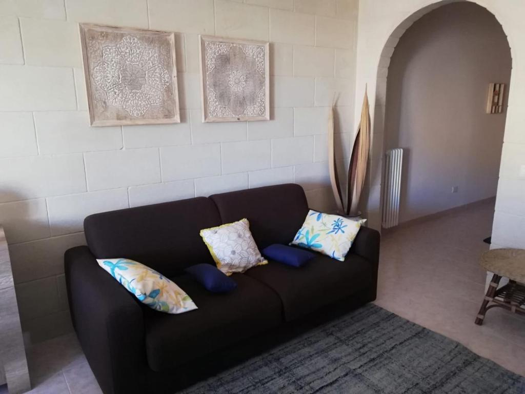 a black couch with pillows in a living room at La Casa di Giulia in Otranto