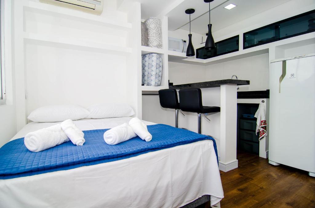 a bedroom with a bed with towels on it at Na rua do Balneário Shopping/Rodoviaria HK4532 in Balneário Camboriú