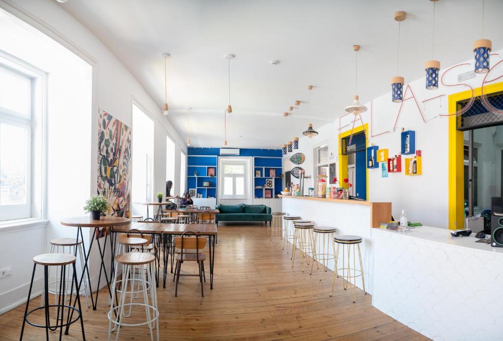 a living room with tables and stools in a room at Safestay Lisbon Bairro Alto in Lisbon