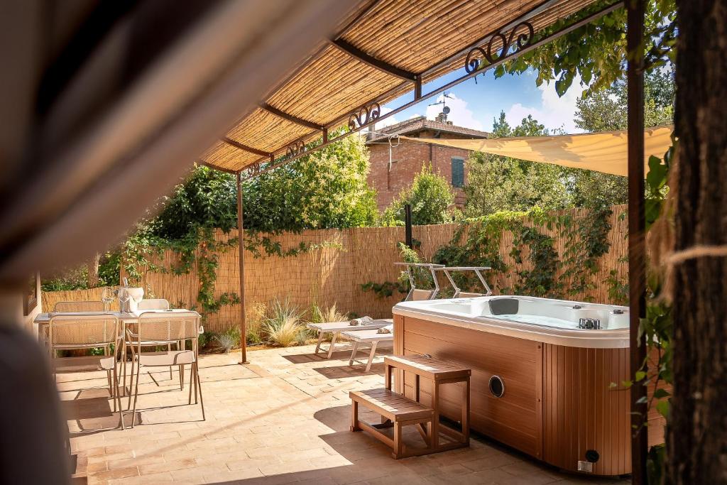 a patio with a tub and a table and chairs at Fontarcella, Heart & Roots in Petrignano sul Lago