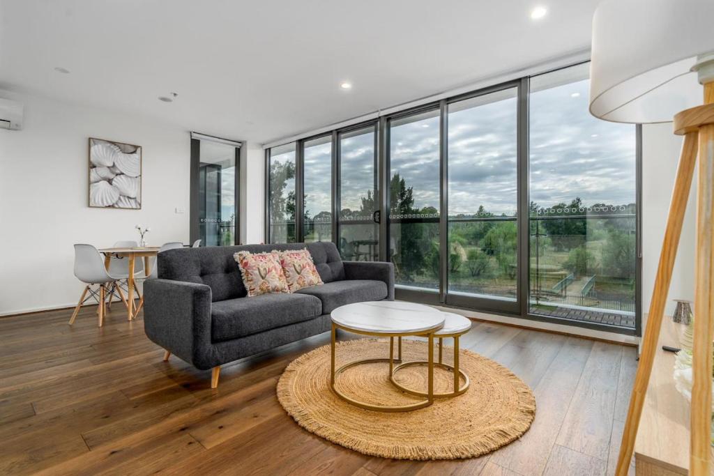 een woonkamer met een bank en een tafel bij Stylish 2BR Apt 5 mins to Canberra Hospital - Hosted by Canstay in Phillip