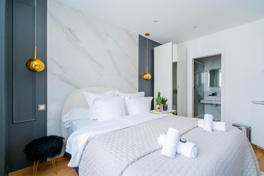 une chambre avec un grand lit blanc avec des oreillers blancs dans l'établissement Luxurious Apartment with Stylish Design and Comfort - 104, à Paris