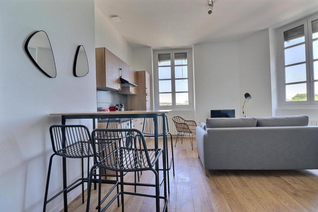 un salon avec un canapé, une table et des chaises dans l'établissement Le Quai d'Or - Apartment for monthly rental - Lyon 4th, à Lyon