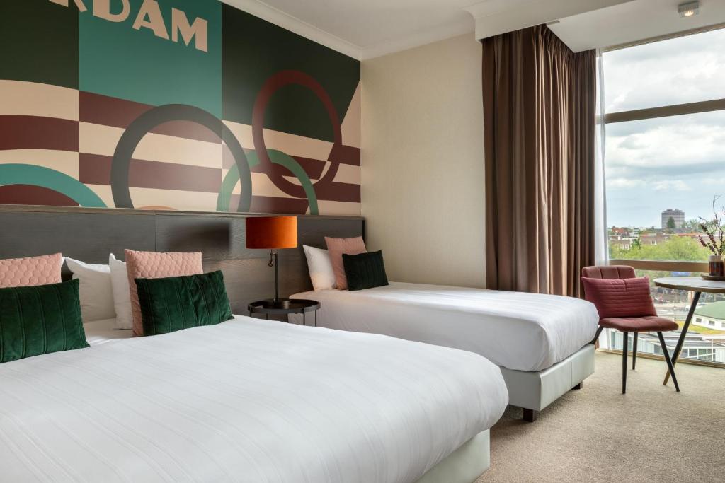 a hotel room with two beds and a window at Apollo Hotel Amsterdam, a Tribute Portfolio Hotel in Amsterdam