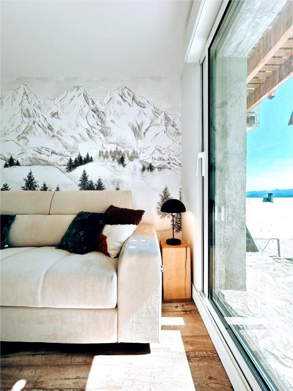 un salon avec un canapé et une fresque murale de montagne recouverte de neige dans l'établissement Chalet St Lary 4 pers 100mdespistes classé 4 étoiles, à Saint-Lary-Soulan