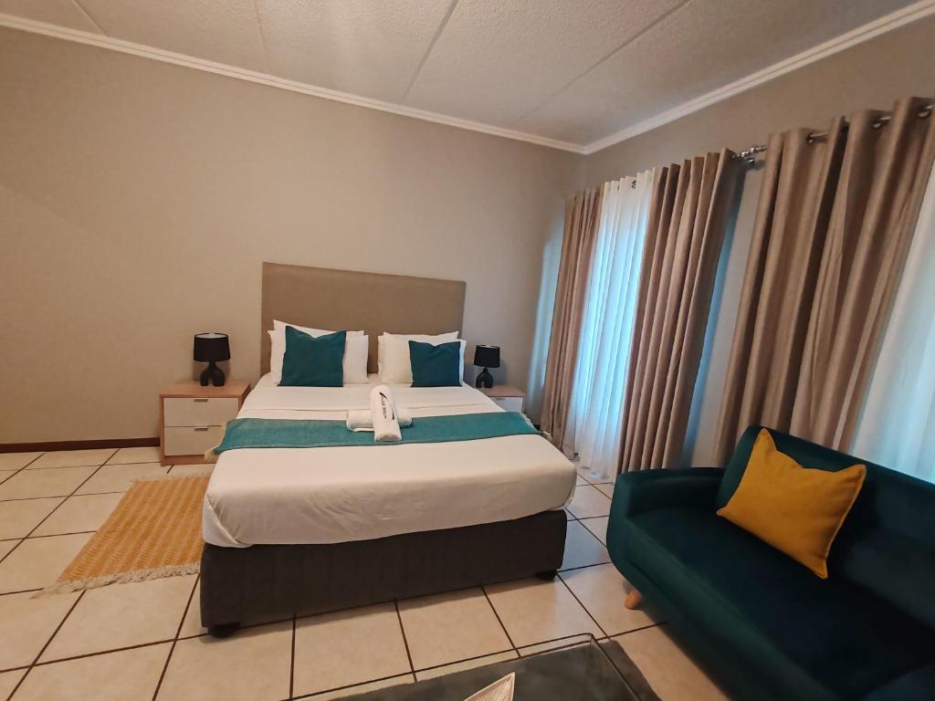 a bedroom with a large bed and a couch at Tevin Nest 2 in Sandton