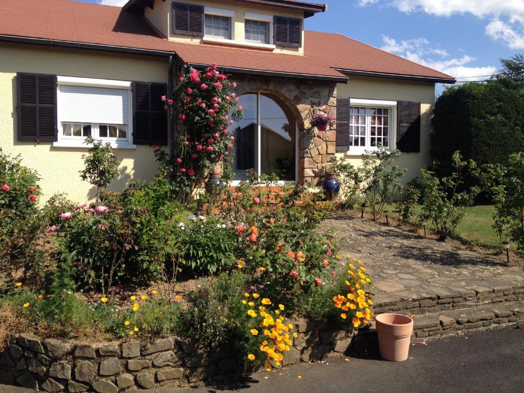 une maison avec un bouquet de fleurs dans la cour avant dans l'établissement Maison familiale, à Paulhac