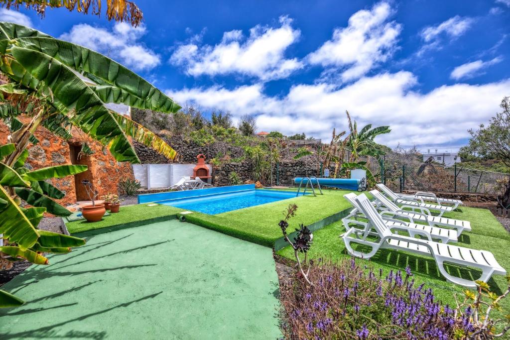 a backyard with a swimming pool and lawn with lounge chairs at Sombrero de Pico C in El Paso