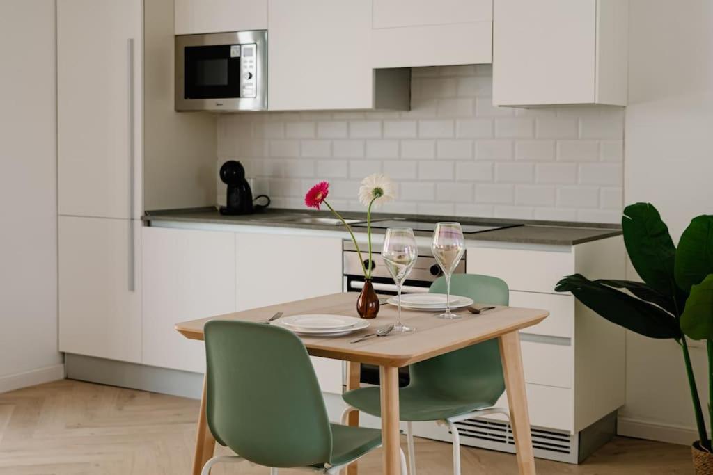 a kitchen with a wooden table with chairs and wine glasses at Sliema Main Street Luxury Suite 7 in Sliema