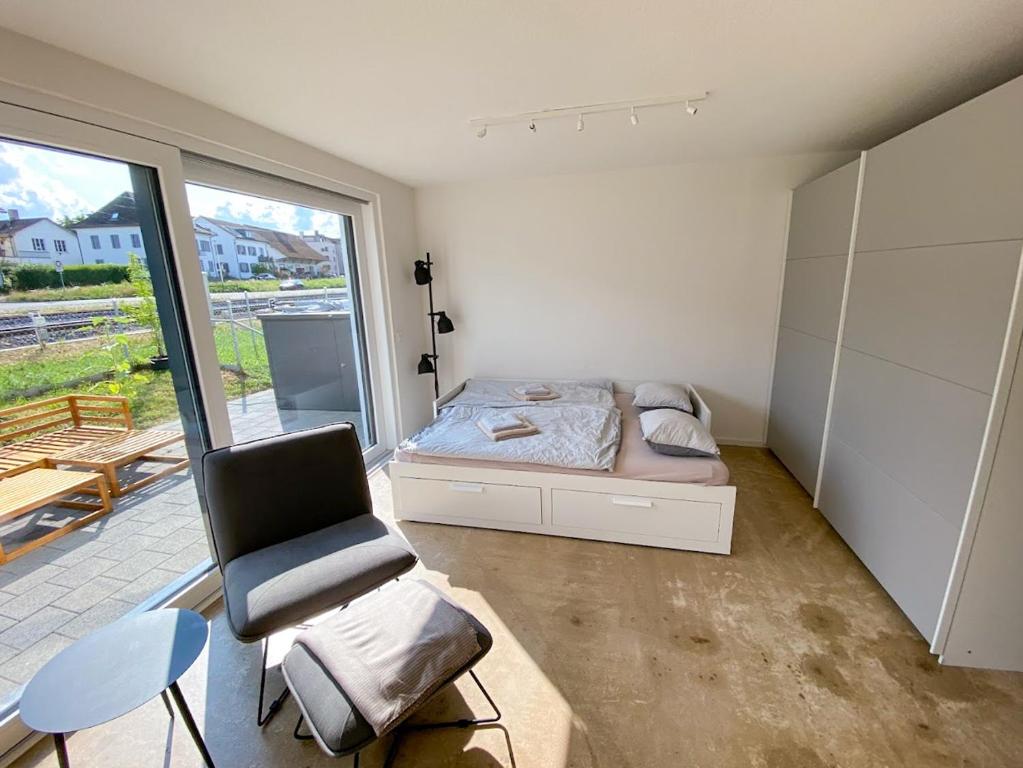 una camera da letto con un letto, una sedia e una finestra di Lakeside Ermatingen a Ermatingen