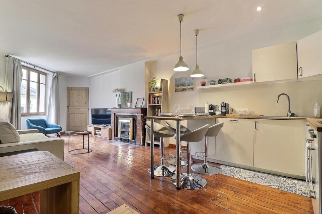 une cuisine et un salon avec une table et des chaises dans l'établissement Le Marius - Beautiful apartment near the Rhône - Lyon 3rd, à Lyon
